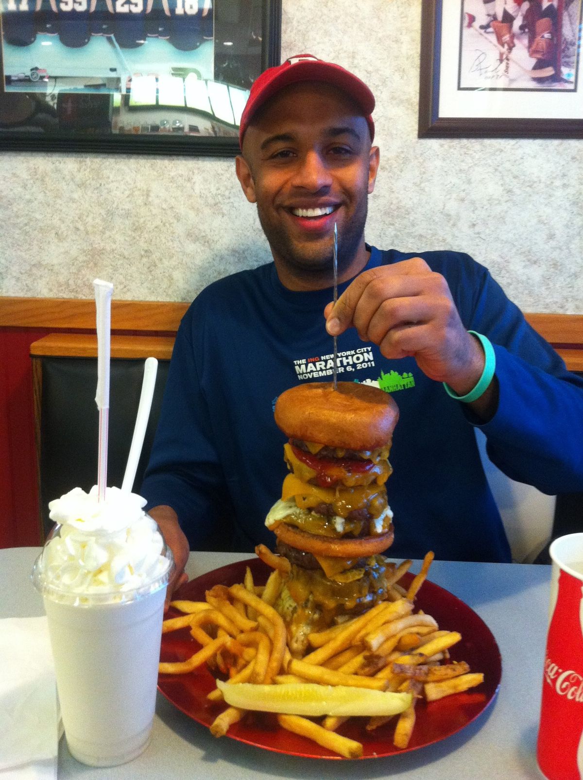 Yasir Salem with a giant stacked burger, fries and a milkshake