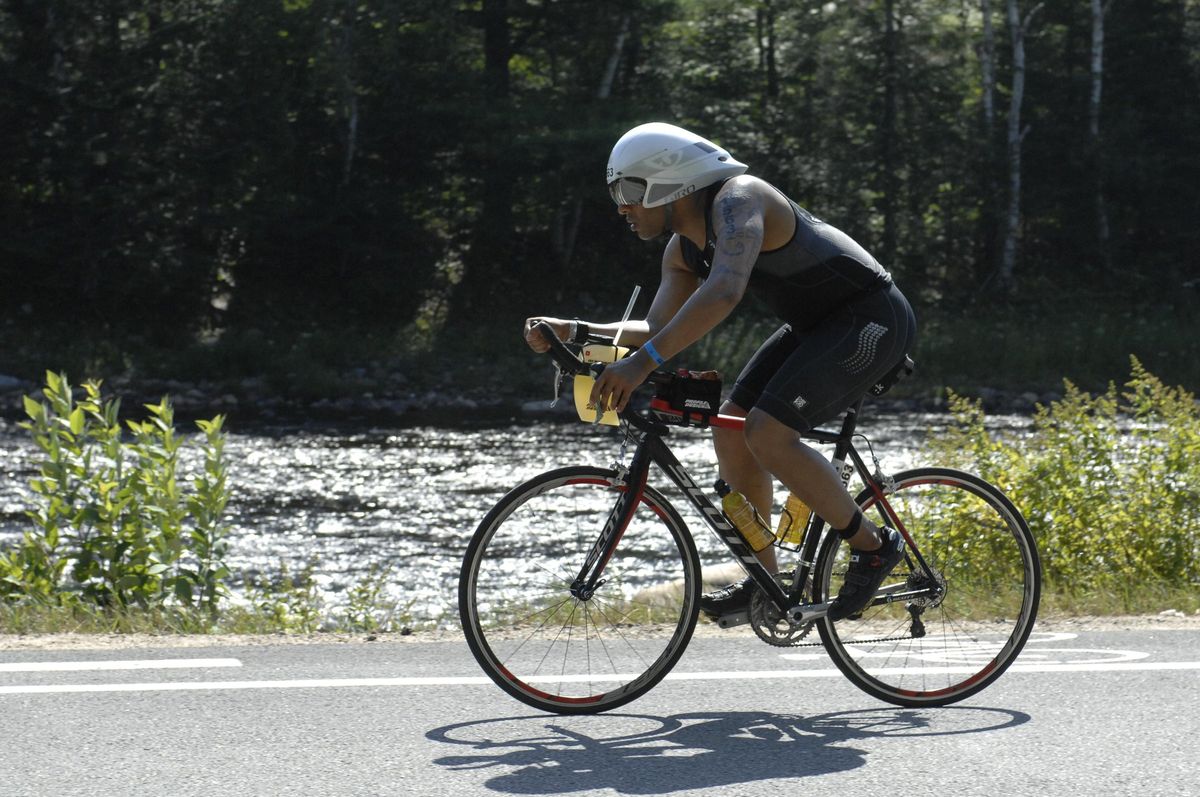 Yasir Salem on a time-trial bike during an Ironman bike leg beside a river