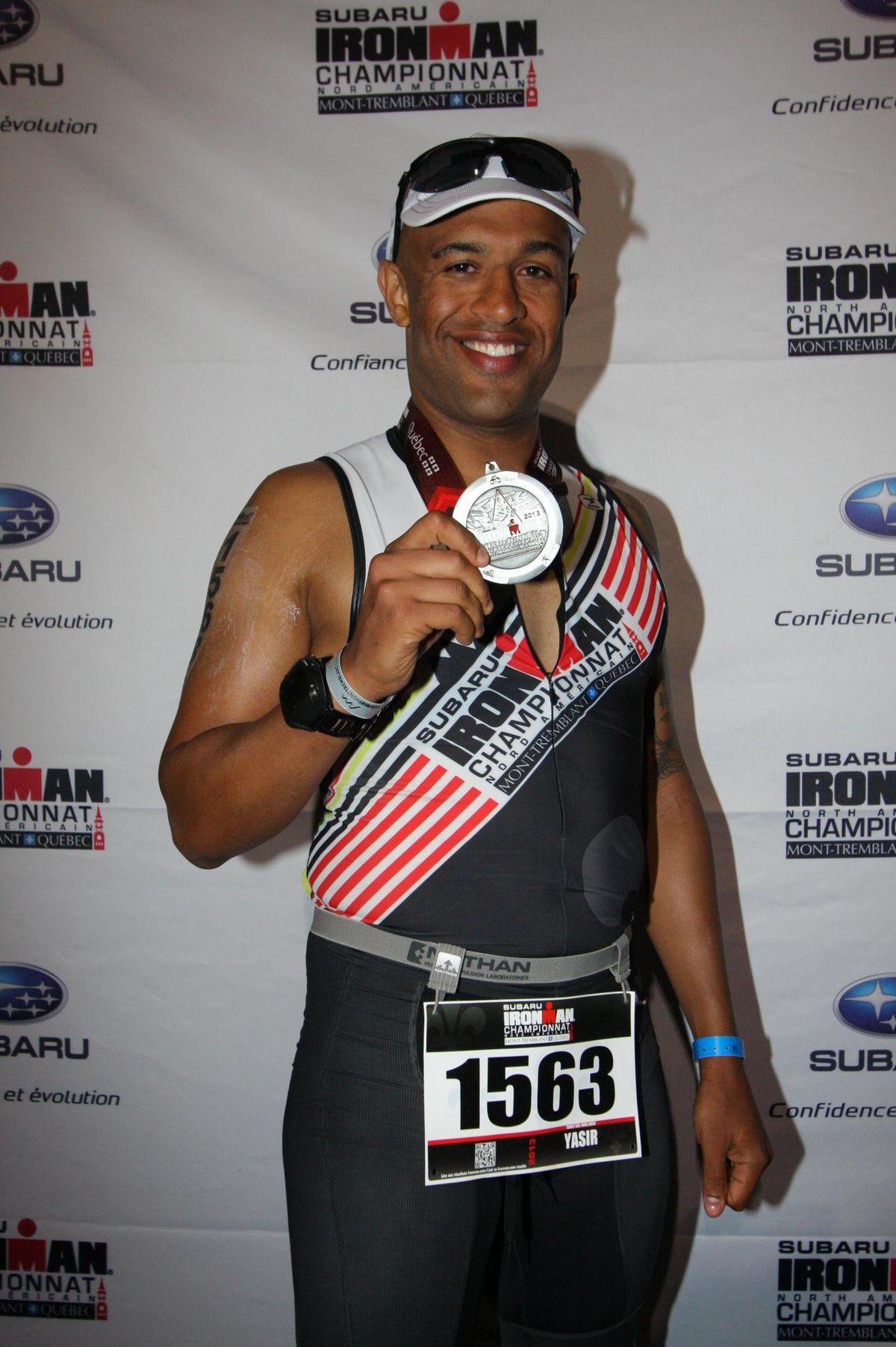 Yasir Salem holding up his Ironman Mont-Tremblant finisher medal
