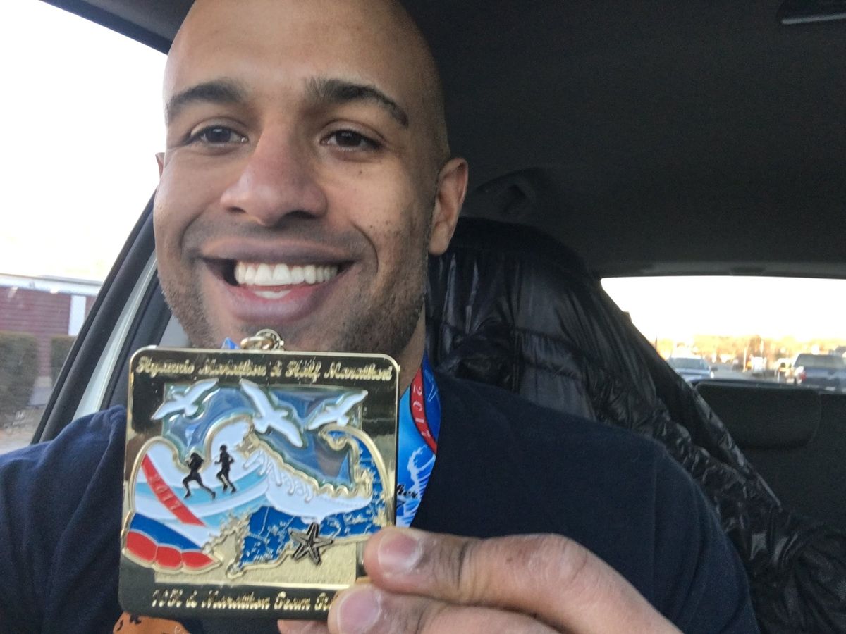 Yasir Salem holding up his 2017 Hyannis Marathon finisher medal